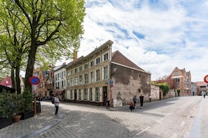 A cobblestone street with historic buildings, a no parking sign, and pedestrians. - Amazing scenic city view room The Lake Suites (Brugge)