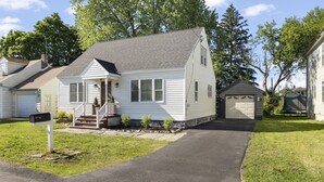 Une maison de plain-pied avec un porche à l’avant, un garage et une boîte aux lettres.