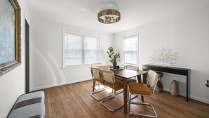 Un espace repas comprenant une table en bois, des chaises et un ventilateur de plafond.