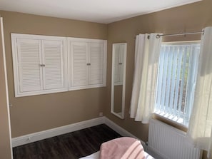 A room with a large window, a radiator, and a mirror on the wall. - Spacious Family Getaway Hot Tub, Sauna & Garden (Conwy Principal Area)