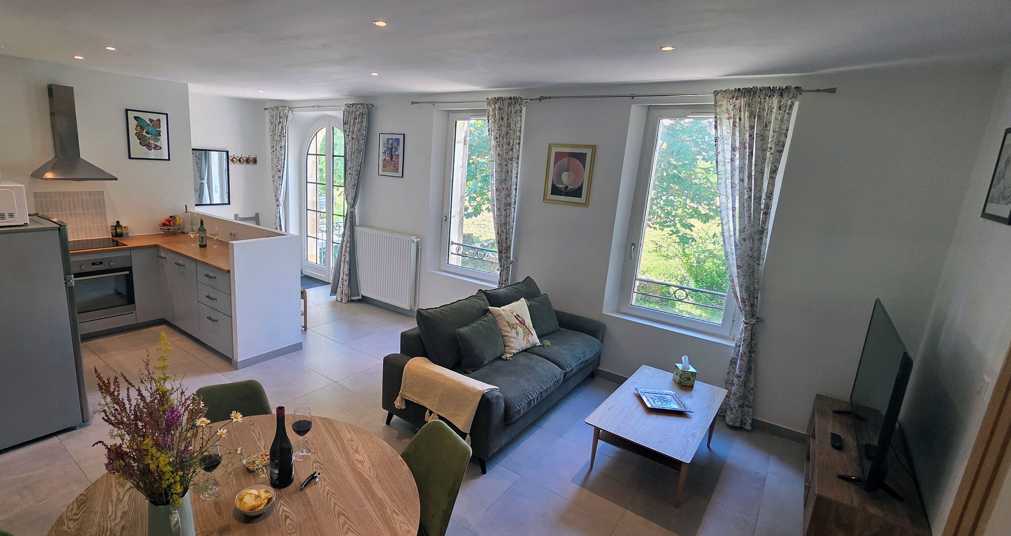En moderne stue med sofa, sofabord og spiseplads.