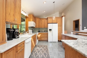 A modern kitchen with wooden cabinets, a white refrigerator, and a marble countertop. - Hudson Valley Private Retreat with 3 bedrooms, 2 living spaces, and a pond. (Hillsdale)