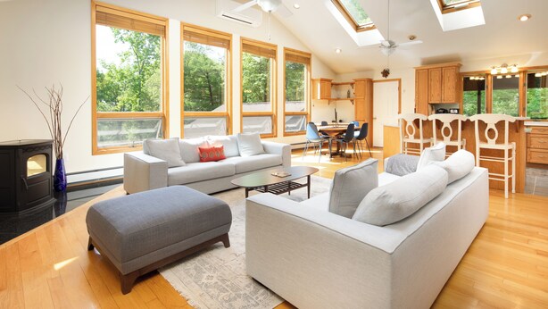 A spacious living room with a fireplace, a dining area, and a kitchen with wooden cabinets. - Hudson Valley Private Retreat with 3 bedrooms, 2 living spaces, and a pond. (Hillsdale)