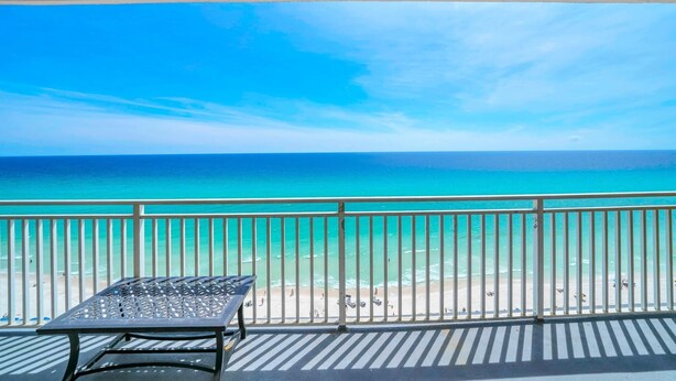 Ein Balkon mit Blick auf den Ozean und den Strand.