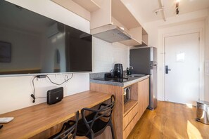Una cocina moderna con encimera de madera, una cafetera y un horno empotrado.
