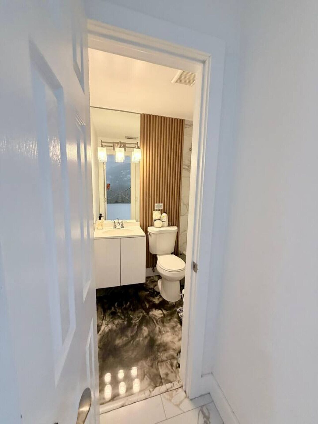 Un baño con inodoro, lavamanos y espejo.
