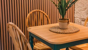 Ein Holztisch mit Stühlen, einer gewebten Tischmatte und einem Blumentopf.