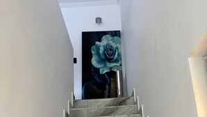 Una escalera de mármol que lleva a una habitación con un gran mural de una rosa azul en la pared.