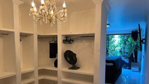 Habitación de hotel con candelabro, ventilador y vistas al exterior.
