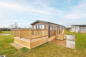A mobile home with a wooden deck, a ramp, and a small porch. - Host & Stay | Stag Lodge (Pickering)