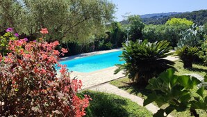 A swimming pool surrounded by lush greenery and trees. - Haven of peace in a villa with pool (Antibes)
