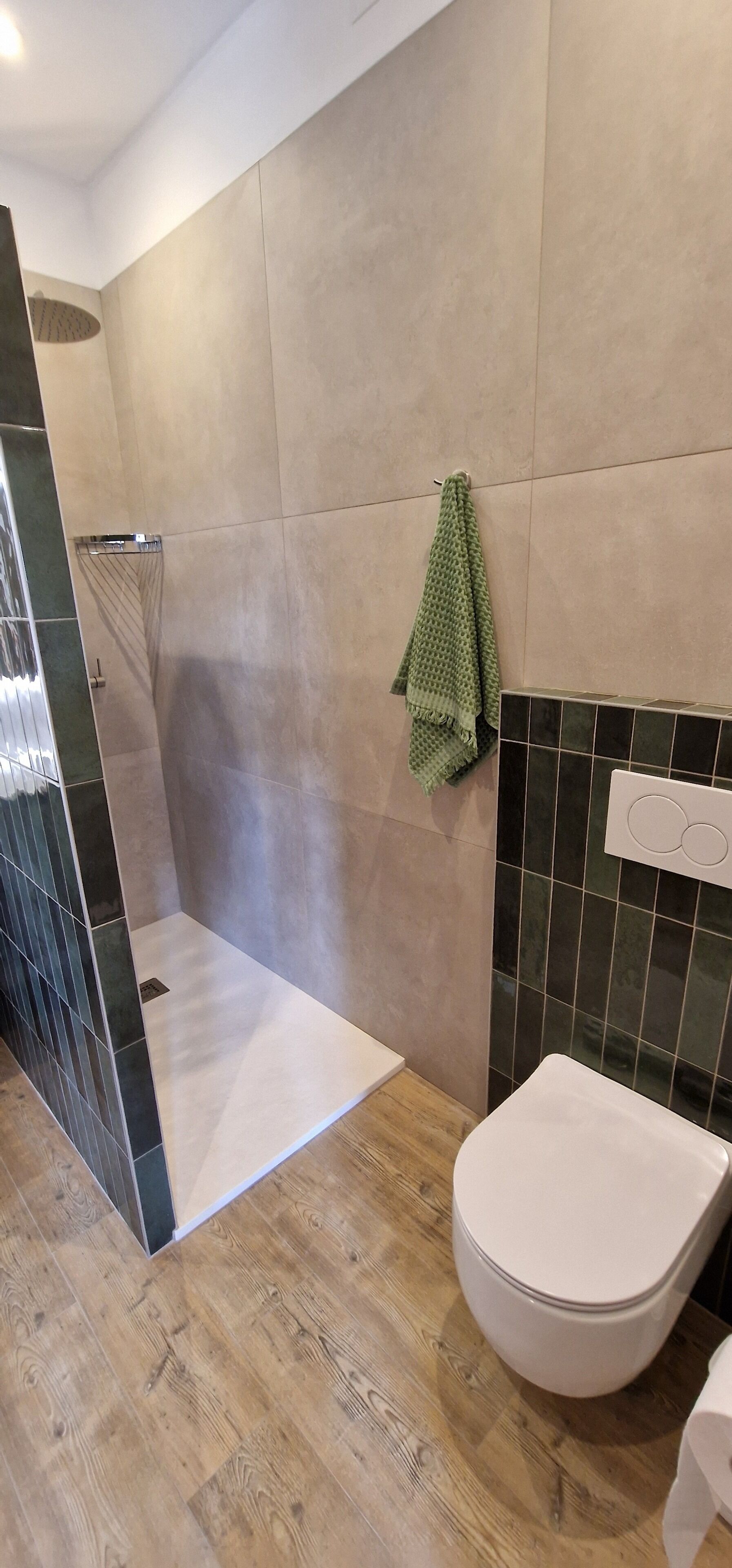 A modern bathroom with a shower, toilet, and tiled walls.