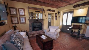 A living room with a fireplace, a sofa, a coffee table, and a television. - The Willow Bed & Breakfast - Room Sage (Veruno)