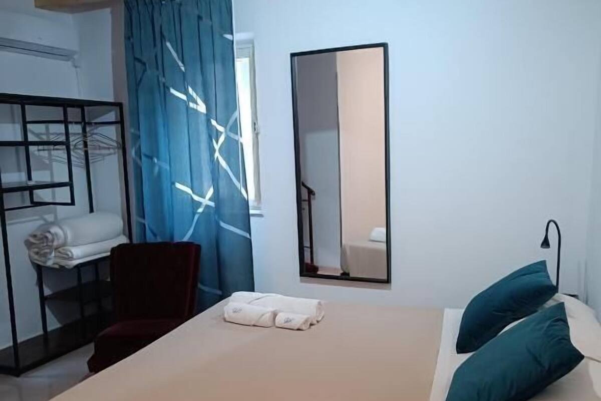 Une chambre à coucher avec un lit, un miroir, une armoire et une chaise.