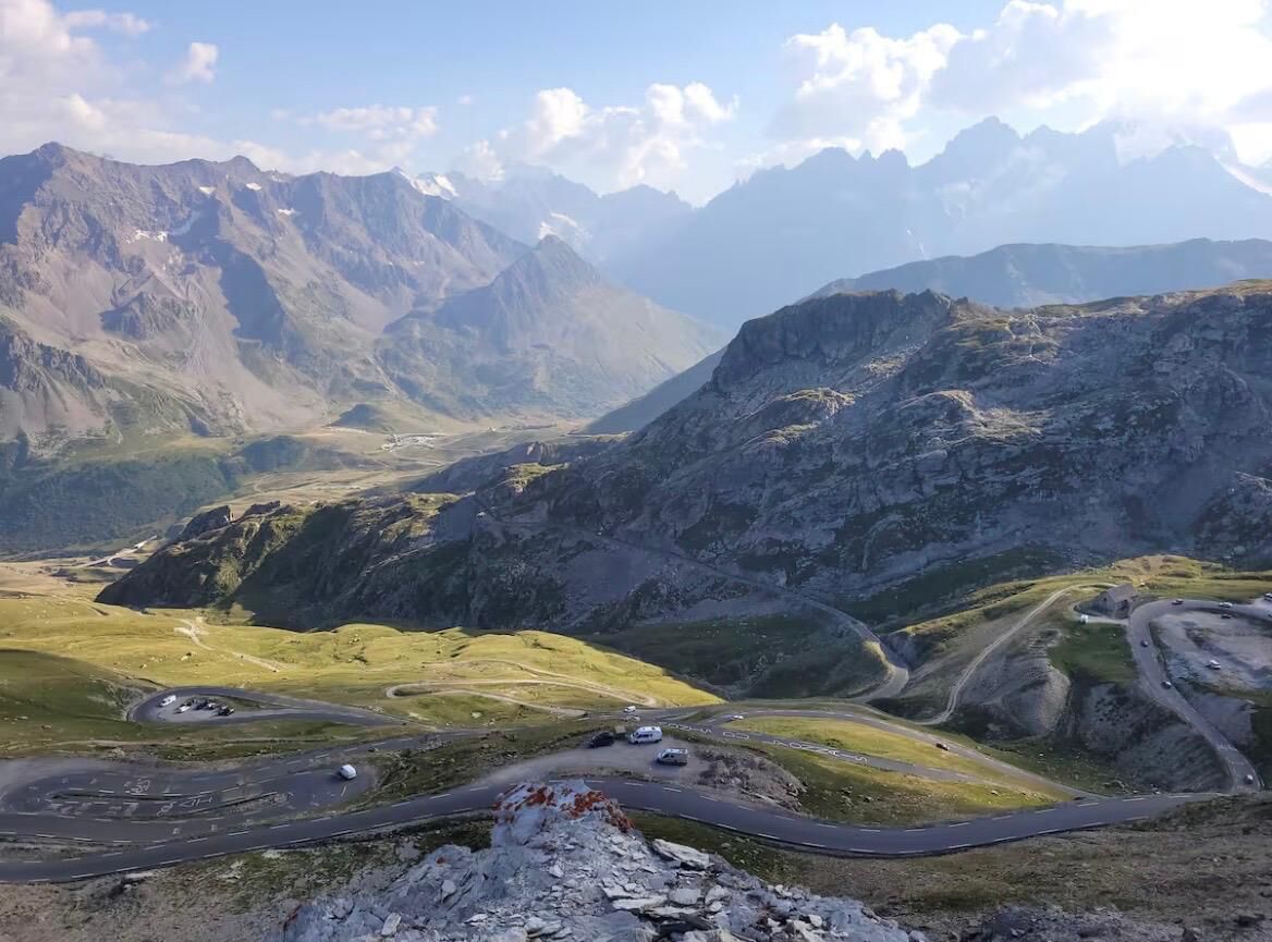 Un paysage montagneux, avec des routes sinueuses et un ciel dégagé.