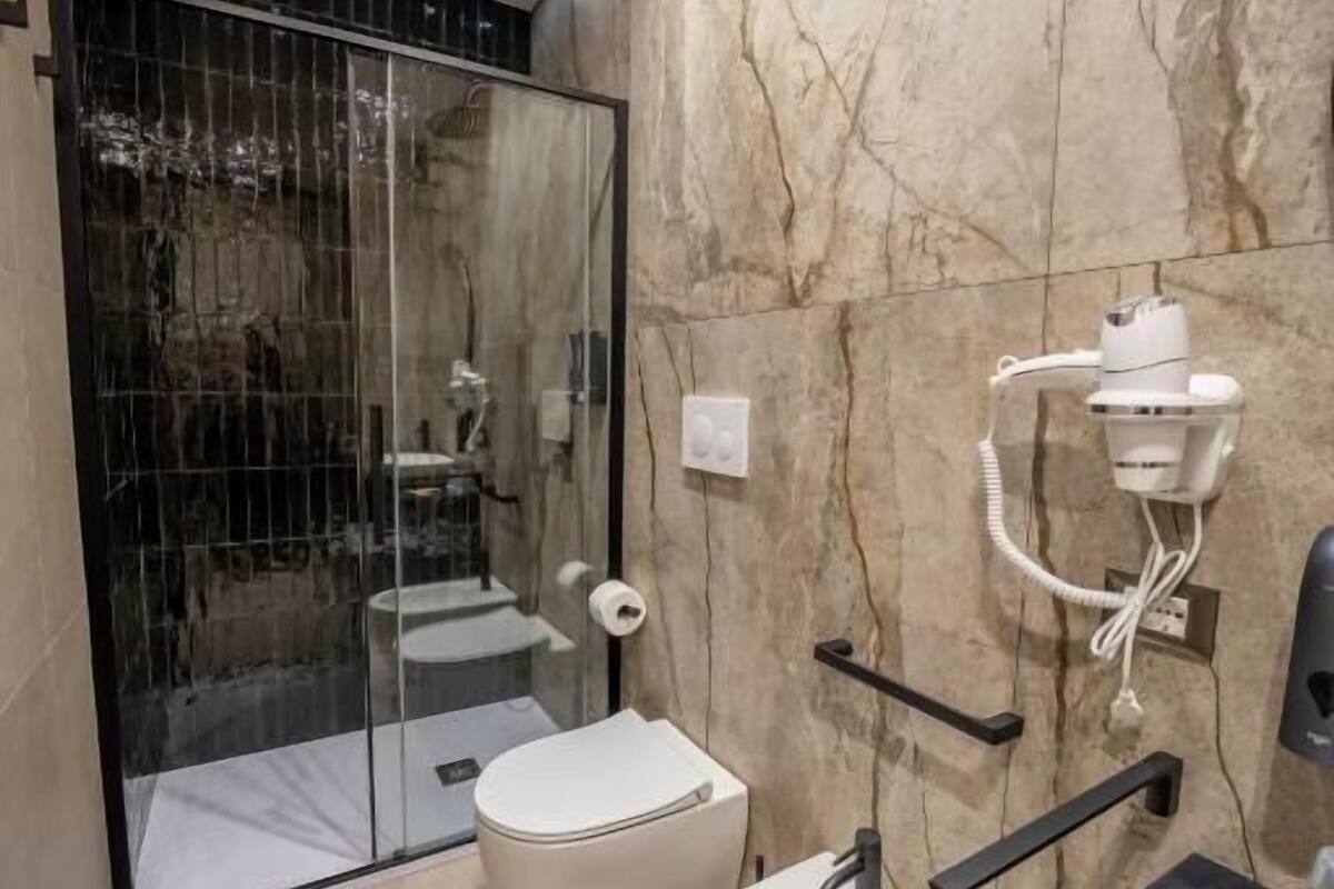 Uma casa de banho moderna com bidé, sanita e zona de duche.