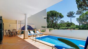 A poolside area with a tiled floor, a pool, lounge chairs, and a table with chairs. - Apartment 'Tulipa' with Private Pool, Wi-Fi, and Air Conditioning (Almancil)