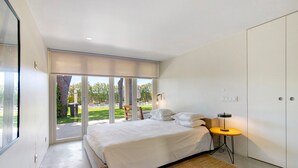 Una camera da letto moderna con un letto grande, un tavolino e un armadio.