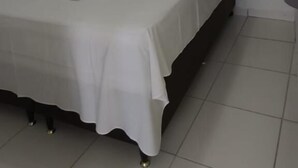 A small, clean room with a single bed, a white air conditioning unit, and a tiled floor. - Hotel Barra de São Miguel (Barra de São Miguel)