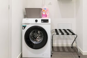 A front-loading washing machine with a drying rack beside it. - Comfortable Leoncino for up to 4 guests (Verona)