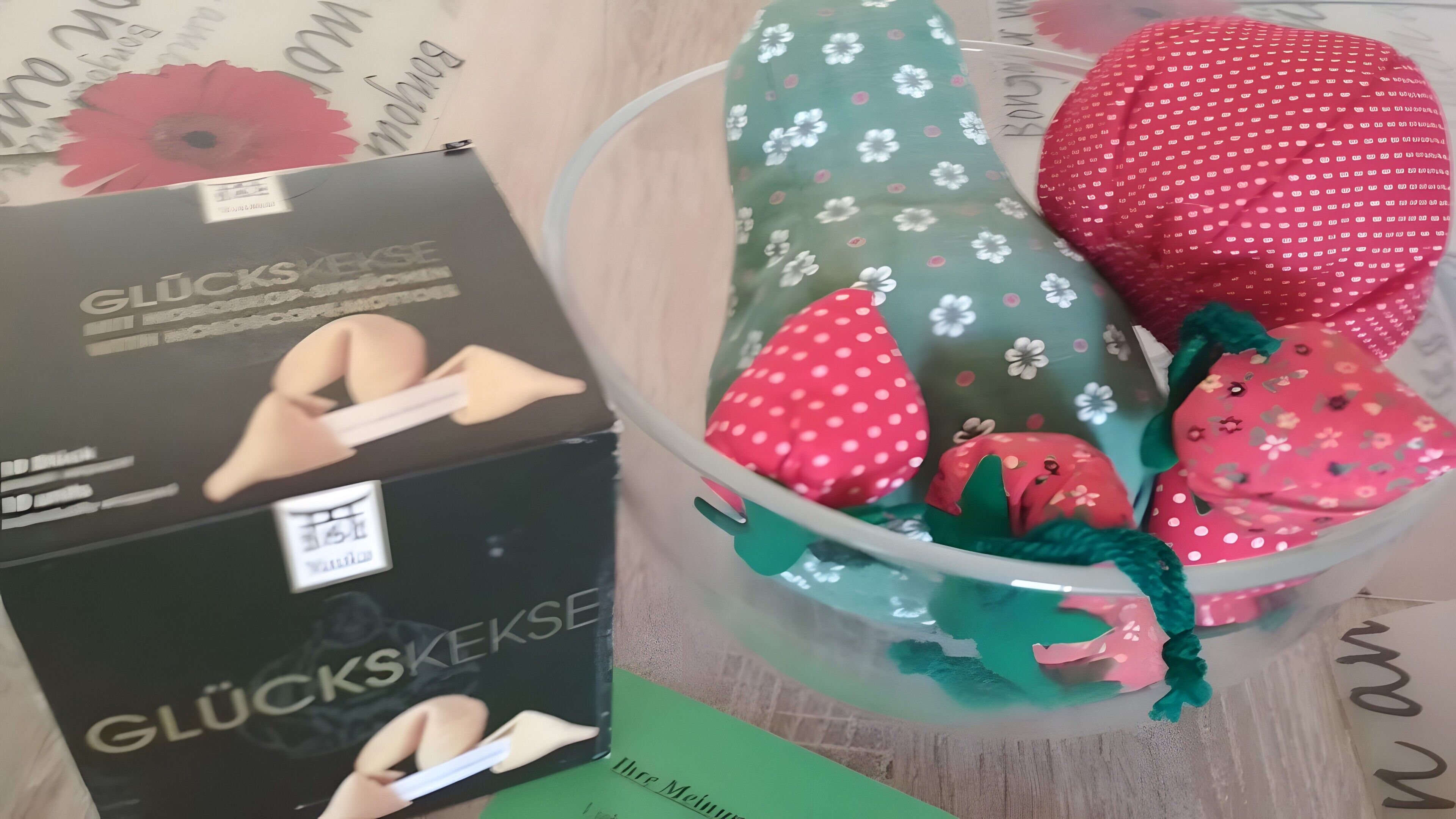 A transparent container with various plush toys and a box labeled 'GLÜCKSKEKSE'.