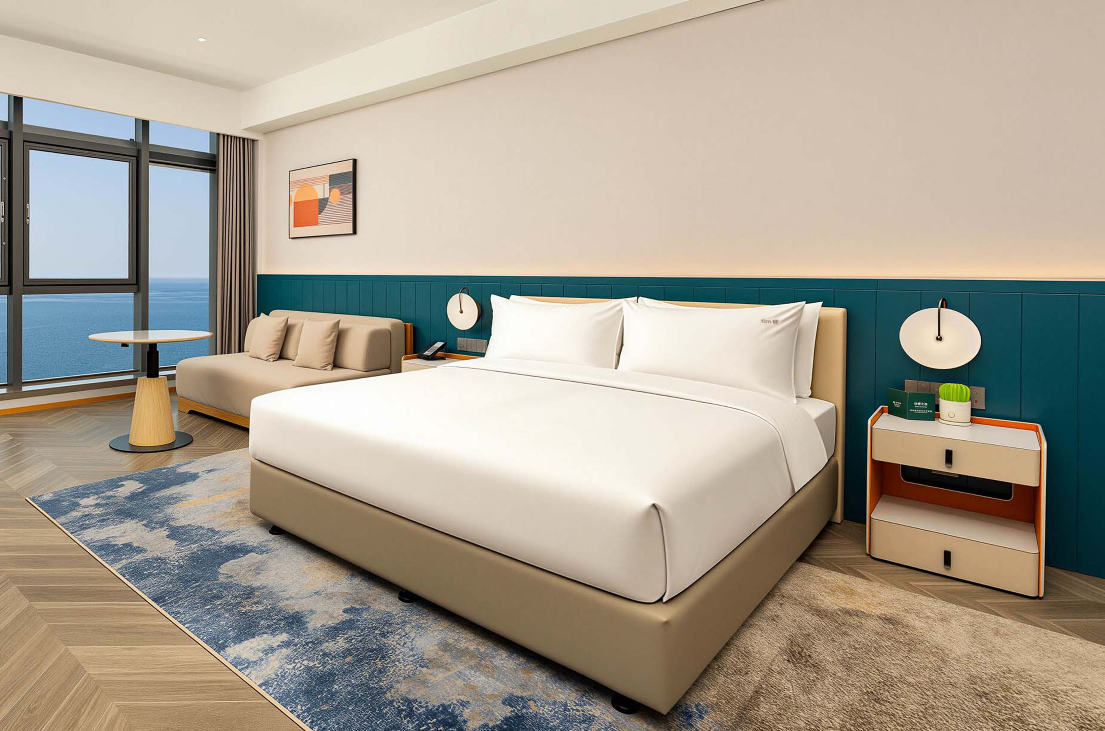 Habitación de hotel moderna con una cama grande, un sofá, una mesita de noche y vistas al mar.
