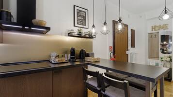 Una cucina moderna con isola centrale, illuminazione a sospensione e pensili in legno.