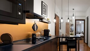 Una cucina moderna con forno a microonde integrato, macchina del caffè e saliera e pepiera sul piano di lavoro.