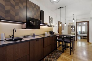 A modern kitchen with a built-in microwave, a sink, and a dining area with a table and chairs. - Apartment 'Your Place in Italy - Rome Apt 2' with Balcony, Wi-Fi and Air Conditioning (Roma)