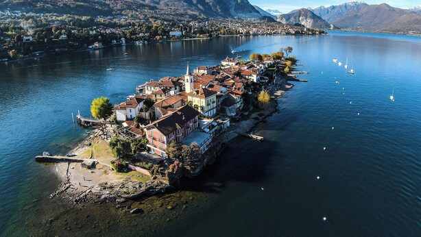 A lakeside village with buildings along the shore, a church, and boats on the water. - Ca'Lina by Lago Maggiore Rentals & Estate (Cannobio)