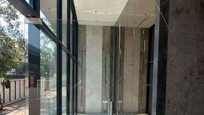Ein modernes Innenarchitektur mit großen Glasfenstern, einem Betonboden und einem Metallgeländer.