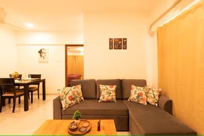 A living room with a sofa, a dining table, and a coffee table.