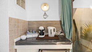 Eine Küche mit einer Bosch-Kaffeemaschine, einem weißen Wasserkocher und einer kleinen Schüssel auf der Arbeitsplatte.