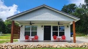 A covered patio with two tables and four chairs, a covered entrance, and a number '4' on the wall. - 5 Charles Farms #4 - NEW CABIN - Wineries, Hiking, and Camp Cana (New Offenburg)