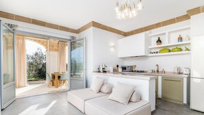 Eine moderne Küche mit Essbereich, einer Couch und einer Glastür zum Außenbereich.