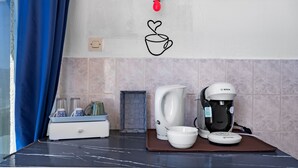 A kitchen with a coffee maker, a kettle, and a tray with cups and glasses. - Studio “Jeux de boules 5” with sea view (Le Pradet)