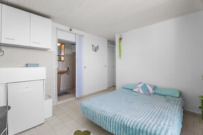 A bedroom with a bed, a small desk, and a white wardrobe. - Studio "Porte Rouge 3" with Sea View (Le Pradet)