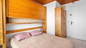 Ein Schlafzimmer mit Etagenbett, Nachttisch und Kleiderschrank.