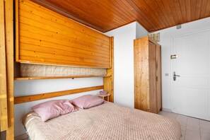 A bedroom with a bunk bed, a small bedside table, and a wardrobe. - Studio 'Porte Rouge 4' with Sea View (Le Pradet)
