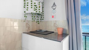 Eine Küche mit Waage, Kaffeemaschine und einem Fenster mit Vorhängen.