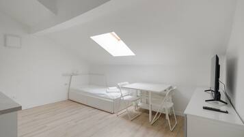 Ein gemütlicher Raum mit Bett, Schreibtisch, Stuhl und Fernseher.
