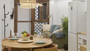 A modern kitchen with a dining table, chairs, a refrigerator, and a potted plant. - Modern loft : Adapted : Smart TV : Air conditioning : 3 people : Air conditioner (València)