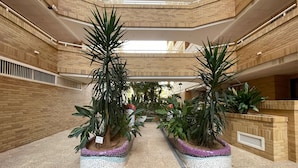 A multi-level atrium with brick walls, potted plants, and a tiled floor. - Spacious 2-bedroom Apartment With Pool View in Oropesa del Mar (Oropesa del Mar)