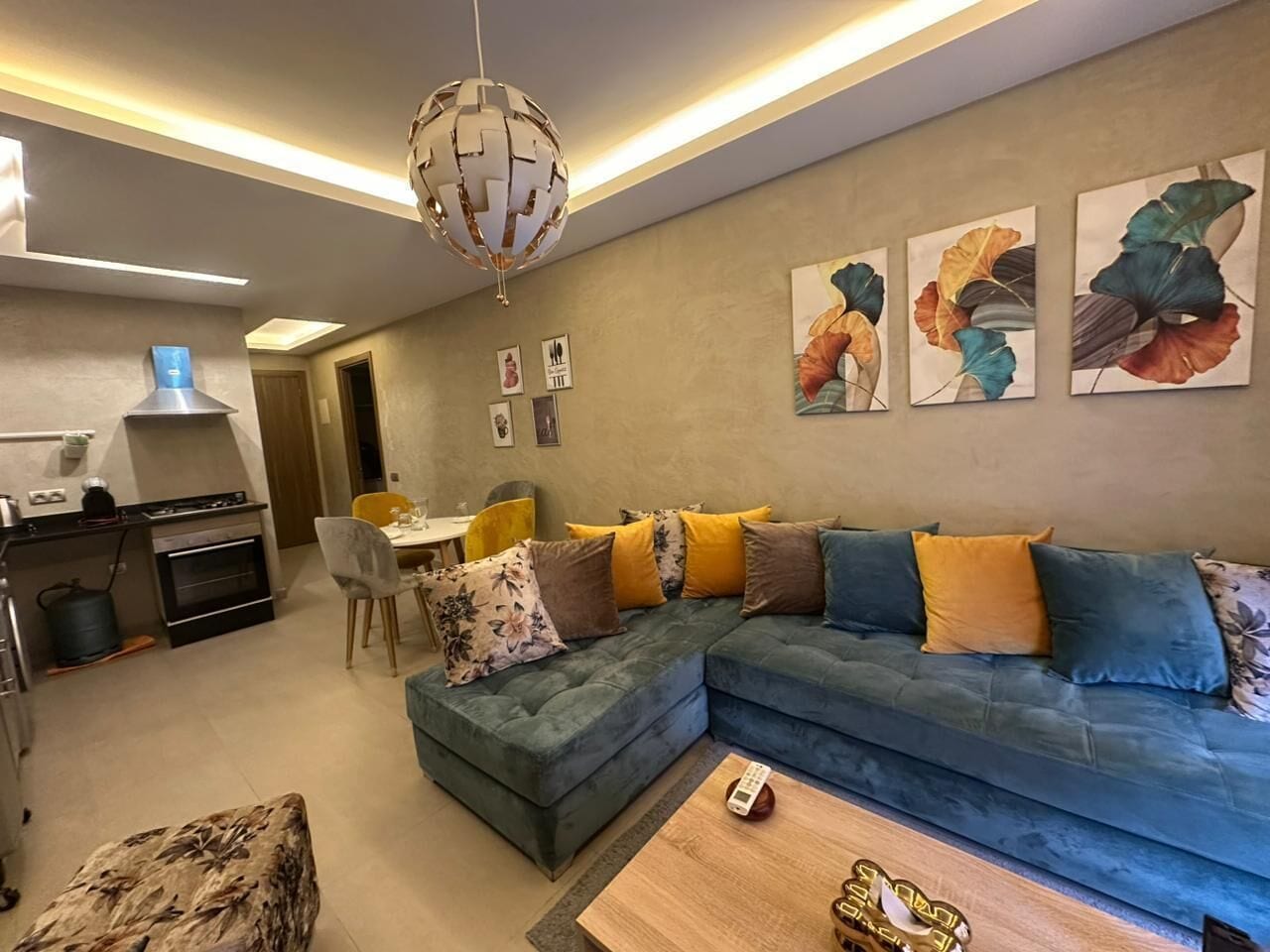Een moderne woonkamer met een hoekbank, een eethoek en een keuken.