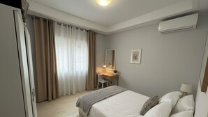 A bedroom with a bed, a desk, a chair, a lamp, and an air conditioning unit. - Cozy house in nouvelle soukra (Ariana)