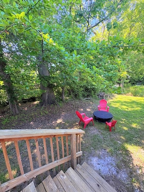 A wooden deck leading to a grassy area with a round table and red chairs. - The Swish & Stay l Cozy 2BR I 15m to RRG I Wi-Fi (Stanton)