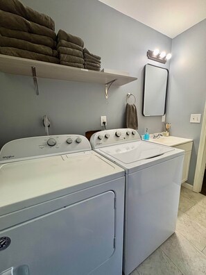 A laundry area with two Whirlpool washers and dryers, a sink, and a towel rack. - The Swish & Stay I Cozy 2BR I 15m to RRG I Wi-Fi (Stanton)