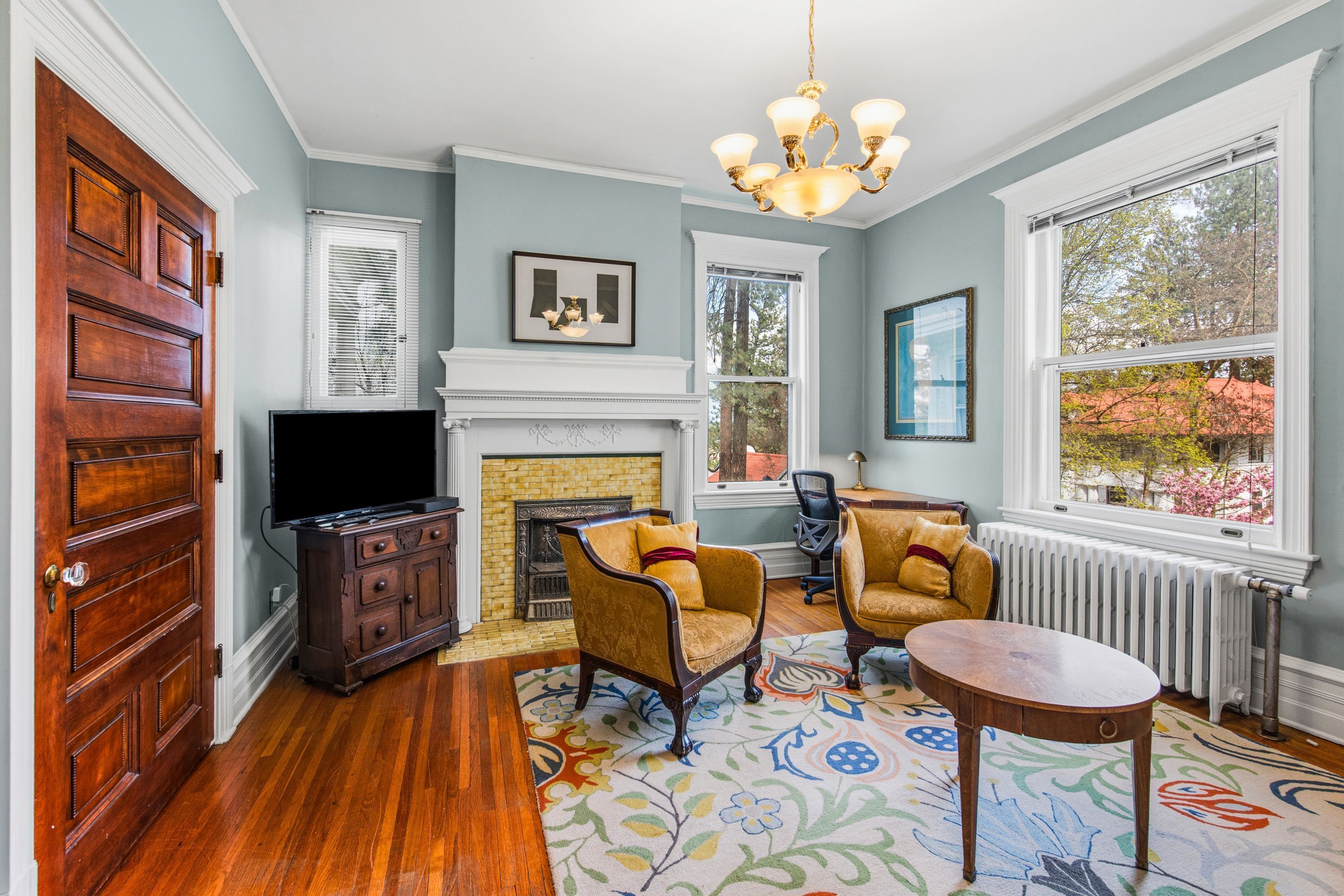 A living room with a fireplace, wooden furniture, and a television.