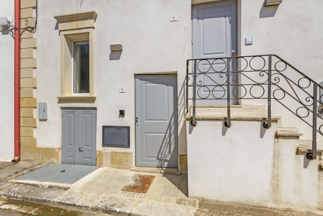 A building with two doors, a window, and a metal staircase.