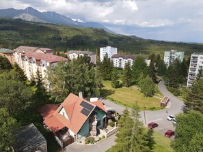 Un quartier résidentiel avec des immeubles à plusieurs étages, une route sinueuse et un paysage montagneux en arrière-plan.